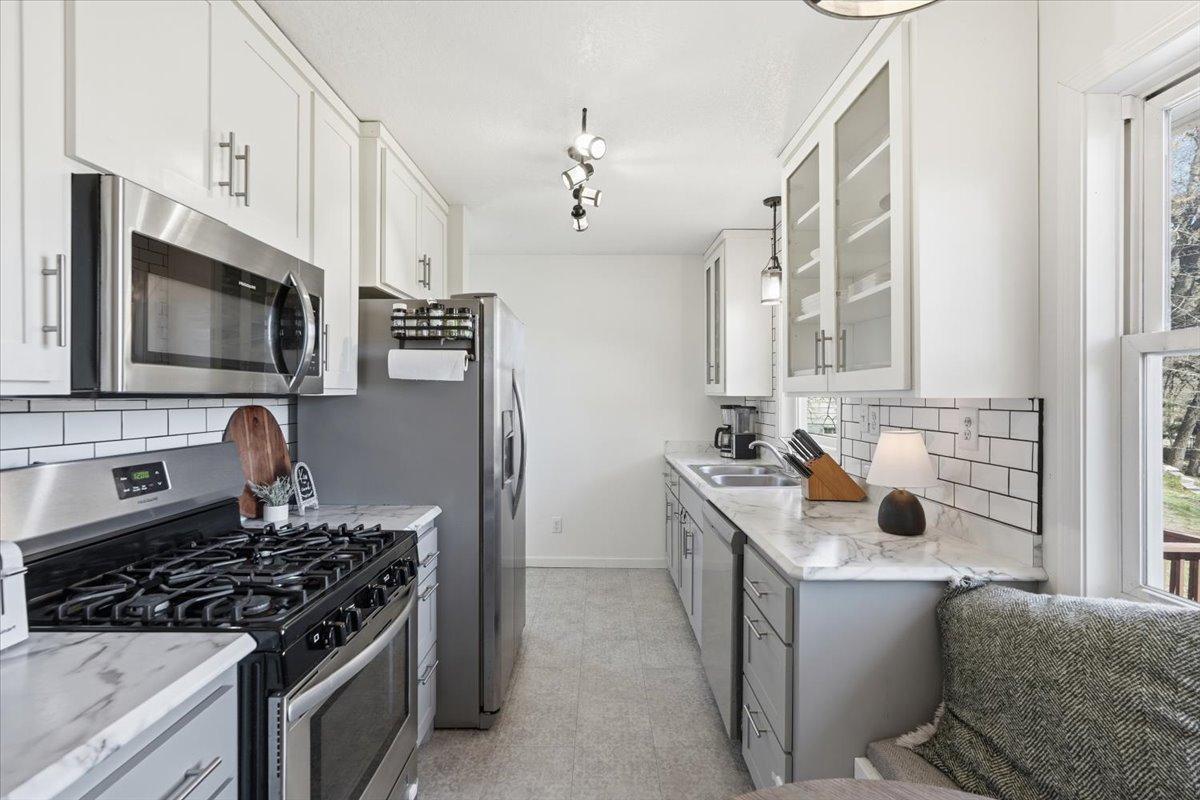Stainless appliances, beautiful countertops and subway tile backsplash.