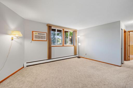 Spacious living room with new paint and large windows bringing in natural light.