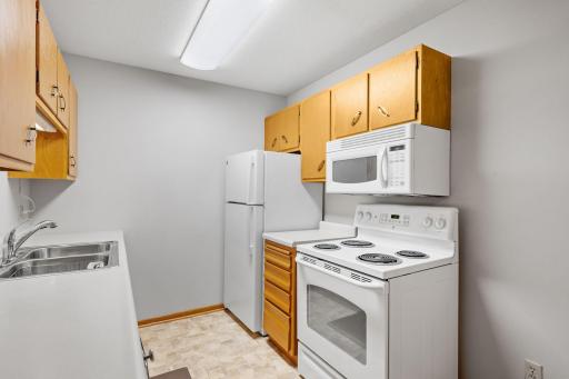 Galley-style kitchen with white appliances and ample cabinet space.