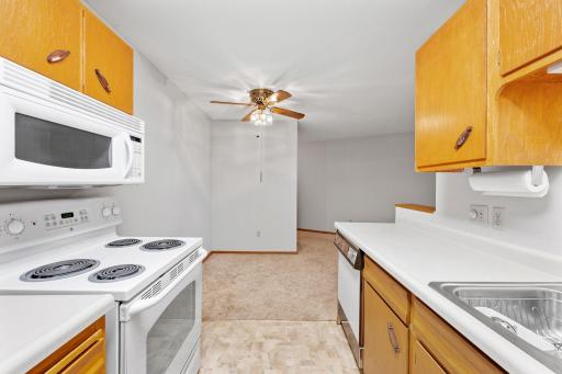 Kitchen view toward dining area with ceiling fan and open layout.