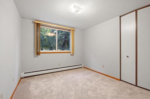 Second bedroom with large window and neutral tones.