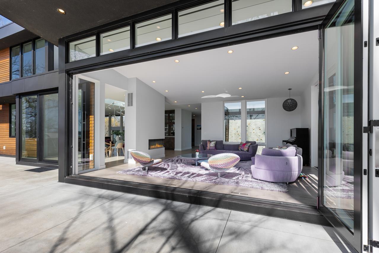 Living room becomes an outdoor space with a sliding windowed wall and a phantom screen.