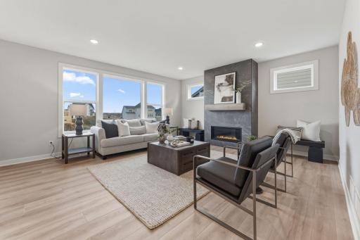 Living room with fully tiled gas fireplace overlooked by kitchen