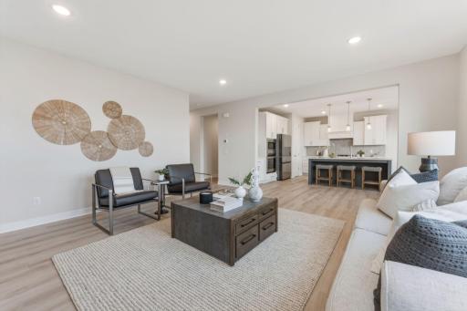 Living room with fully tiled gas fireplace overlooked by kitchen