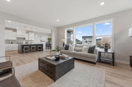 Living room with fully tiled gas fireplace overlooked by kitchen