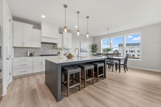 Gourmet kitchen with wall oven and microwave, gas range and built-in hood vent with upgraded stainless steel appliances