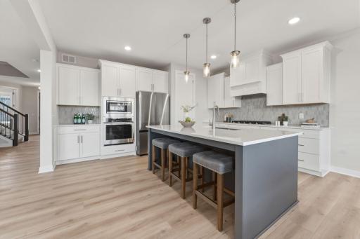 Gourmet kitchen with wall oven and microwave, gas range and built-in hood vent with upgraded stainless steel appliances