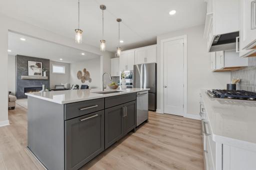 Gourmet kitchen with wall oven and microwave, gas range and built-in hood vent with upgraded stainless steel appliances