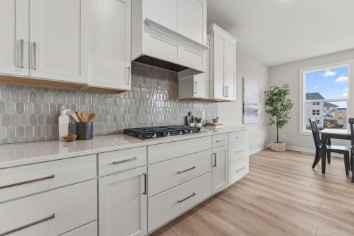 Gourmet kitchen with wall oven and microwave, gas range and built-in hood vent with upgraded stainless steel appliances