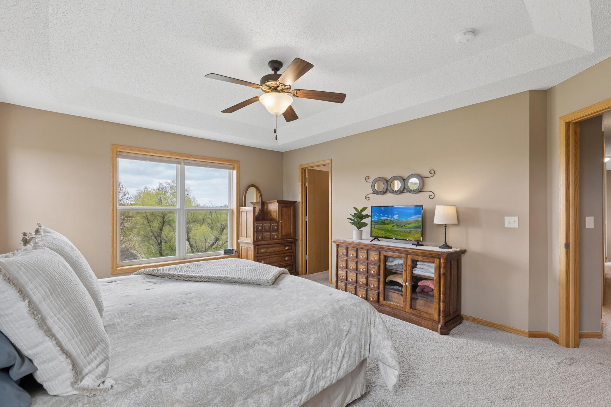 Spacous primary suite features a tray vault ceiling