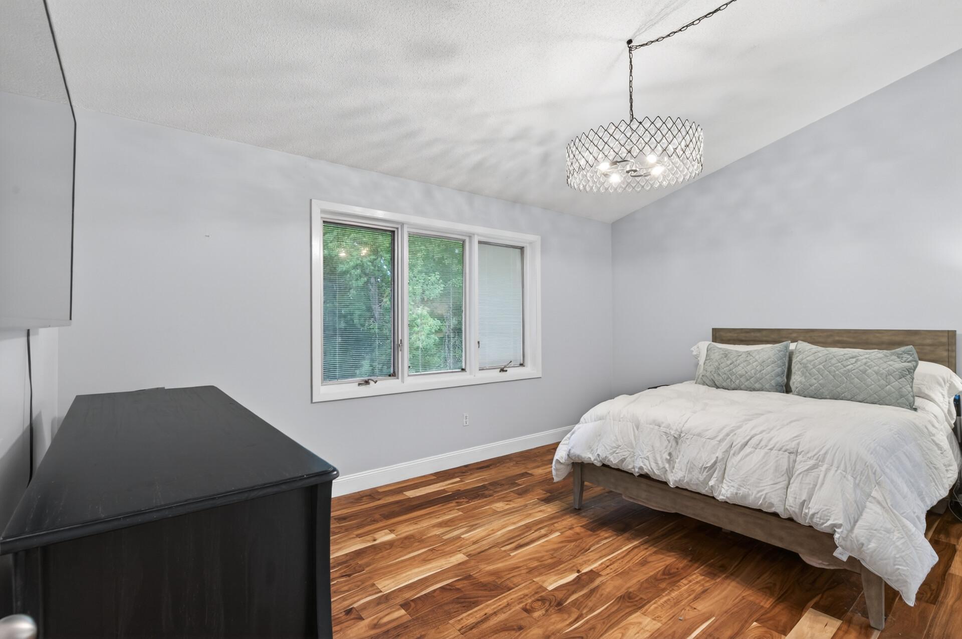 Primary bedroom with vaulted ceilings, private 3/4 primary bath and his and hers walk-in closets, all with wooded views!