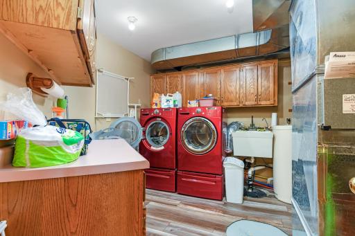 Spacious lower level laundry complete with large folding counter and laundry tub