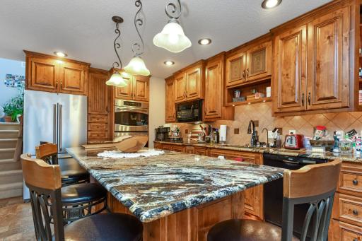 This kitchen is the chef's kiss, featuring a large center island and granite tops.