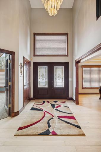 A welcoming grand foyer greets you with soaring space and a striking overhead chandelier.