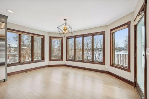 The dining space, bathed in natural light from surrounding windows, provides picturesque views of the pond and peaceful natural scenery.