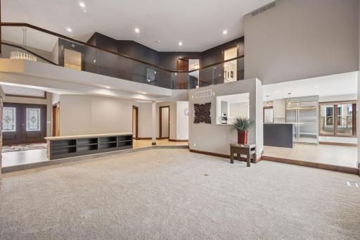 A dramatic catwalk frames the living room below, offering open views and access to the upper-level bedrooms.