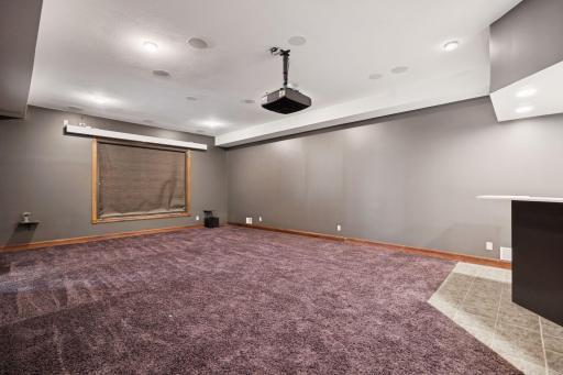 Enjoy a dedicated theater room featuring built-in surround sound, an overhead projector, and a convenient remote-controlled drop-down screen.