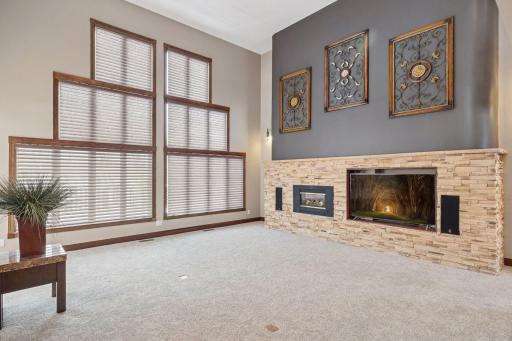 The showstopping vaulted living room features expansive picture windows with electronic blinds, creating a bright, sophisticated focal point.