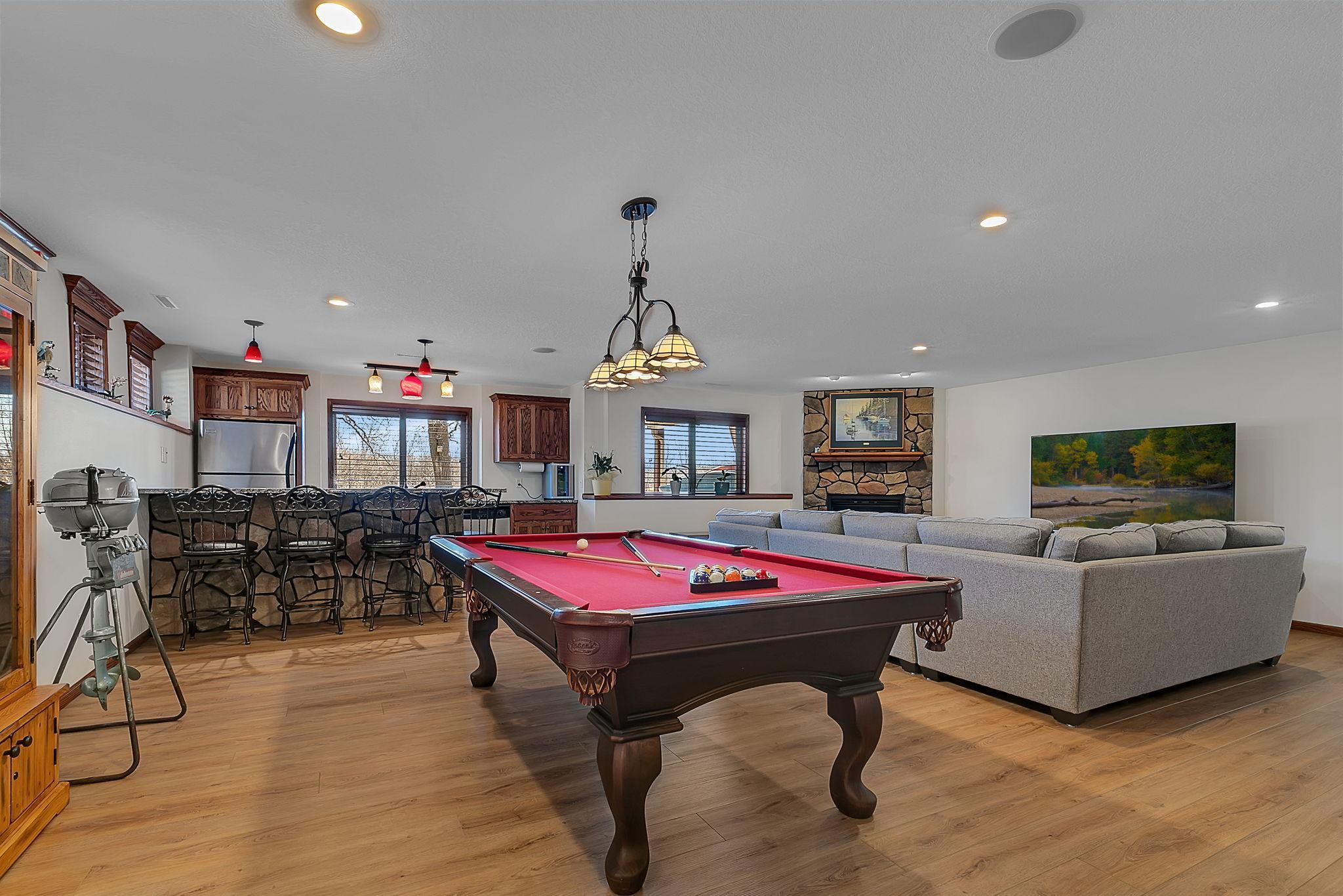 An entertainer’s dream on the lower level, featuring a spacious living area, cozy gas fireplace, wet bar, and room for games and fun.