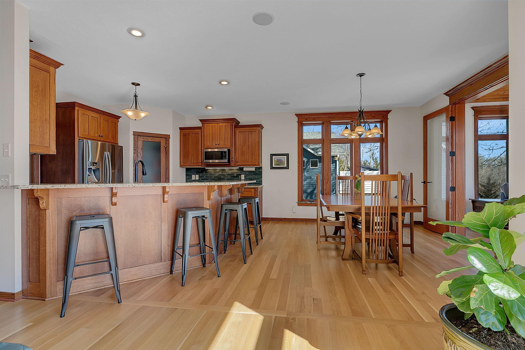 Open-concept kitchen and dining room with an easy, natural flow into the sunroom and living area—bringing in great light and making the whole space feel connected and comfortable.