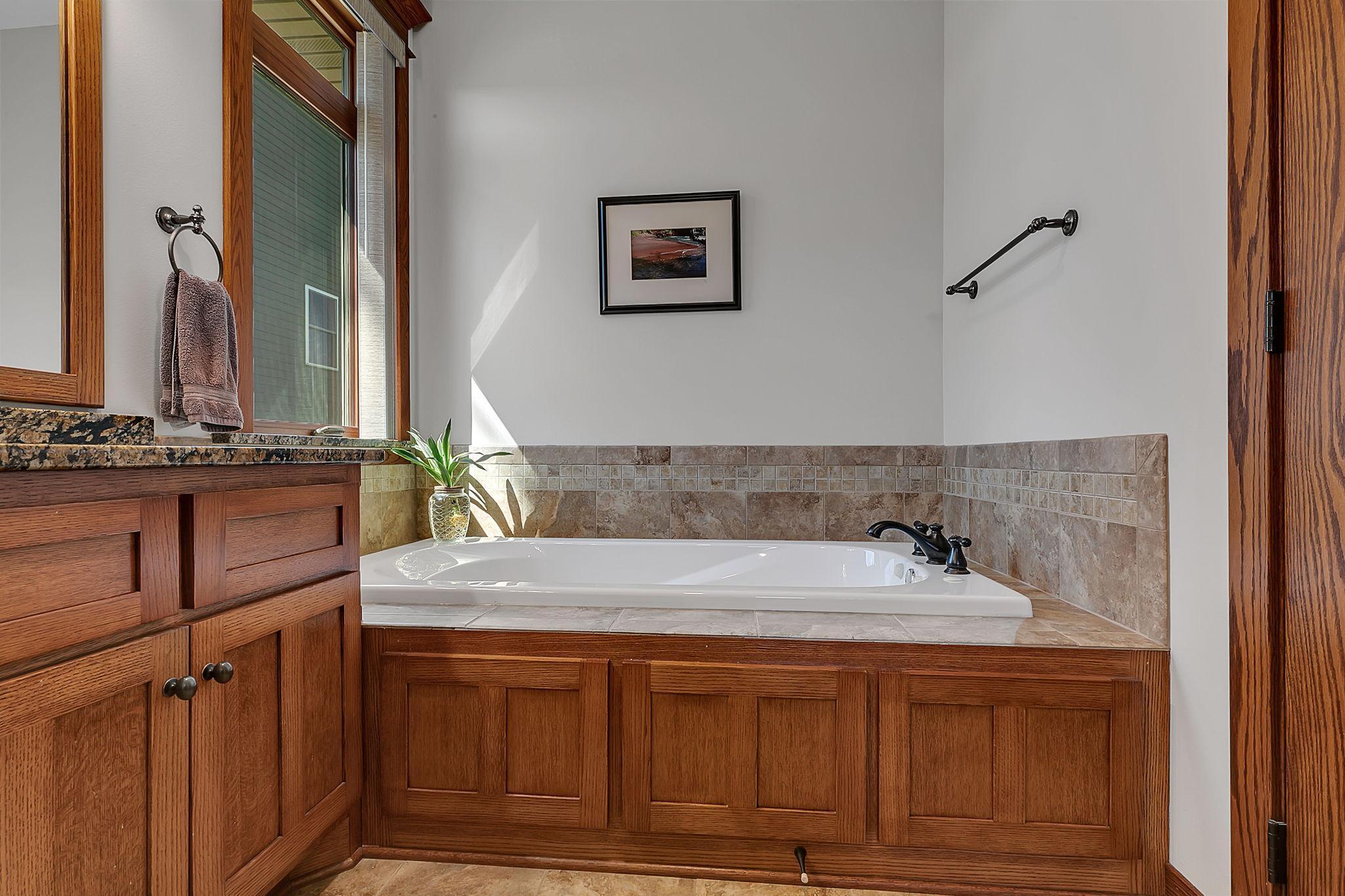 A glimpse of the generously sized soaking tub in the private primary bathroom, designed for ultimate comfort and relaxation.