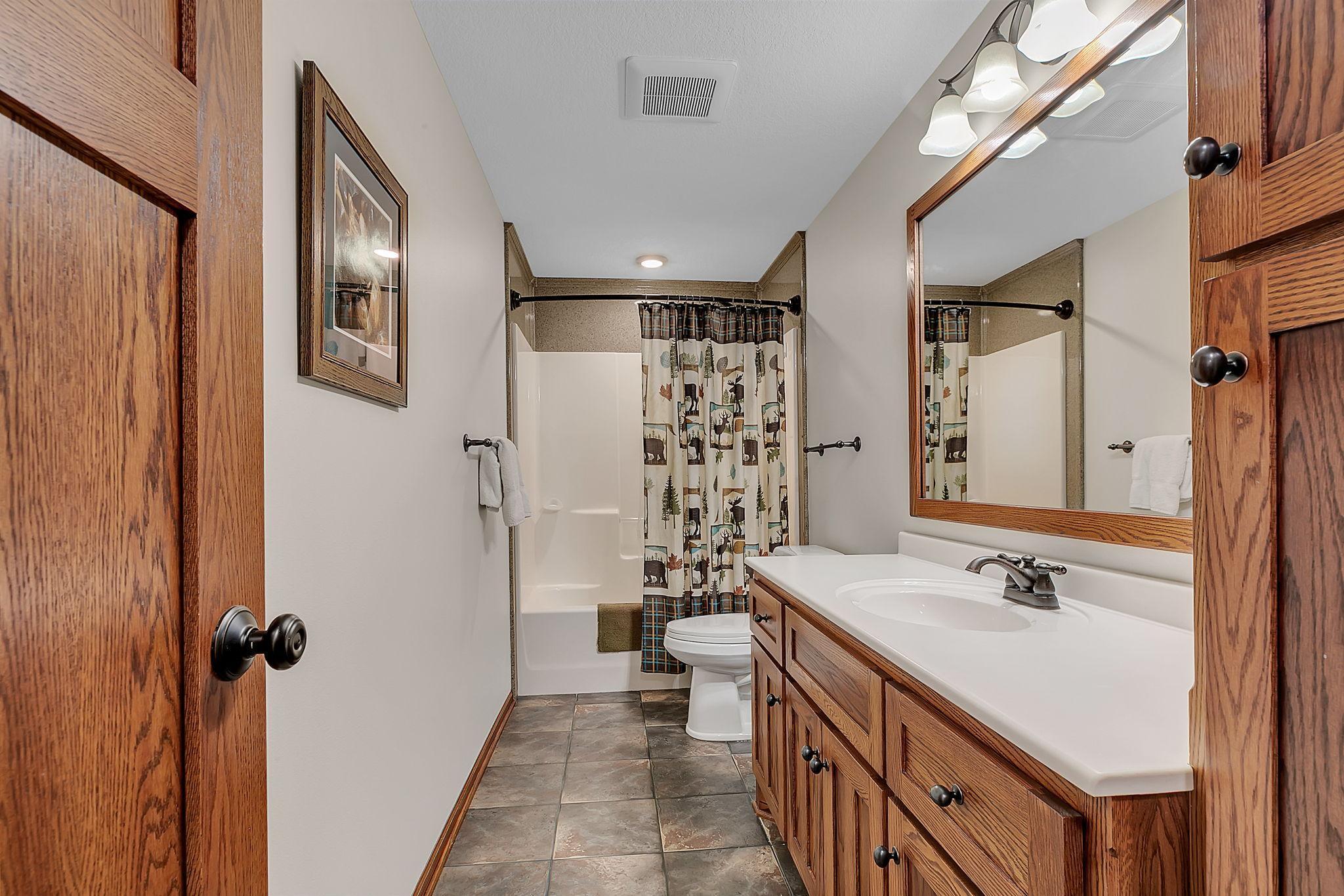 A view of the lower level full bathroom with large vanity.
