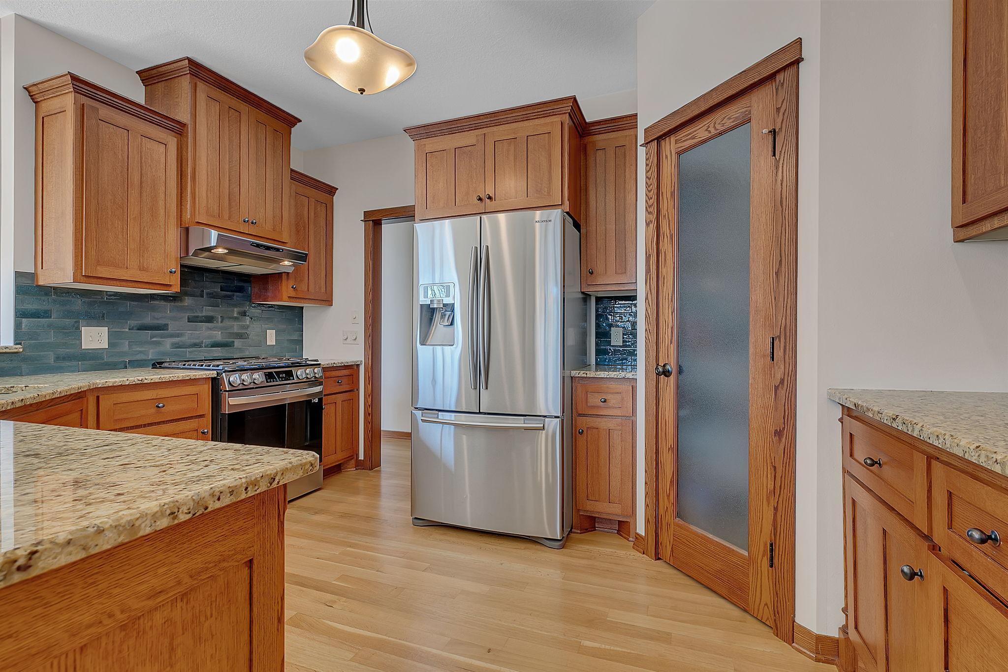 A bright, open kitchen with elegant cabinetry and a gas range topped with a sleek range hood, combining style and functionality.