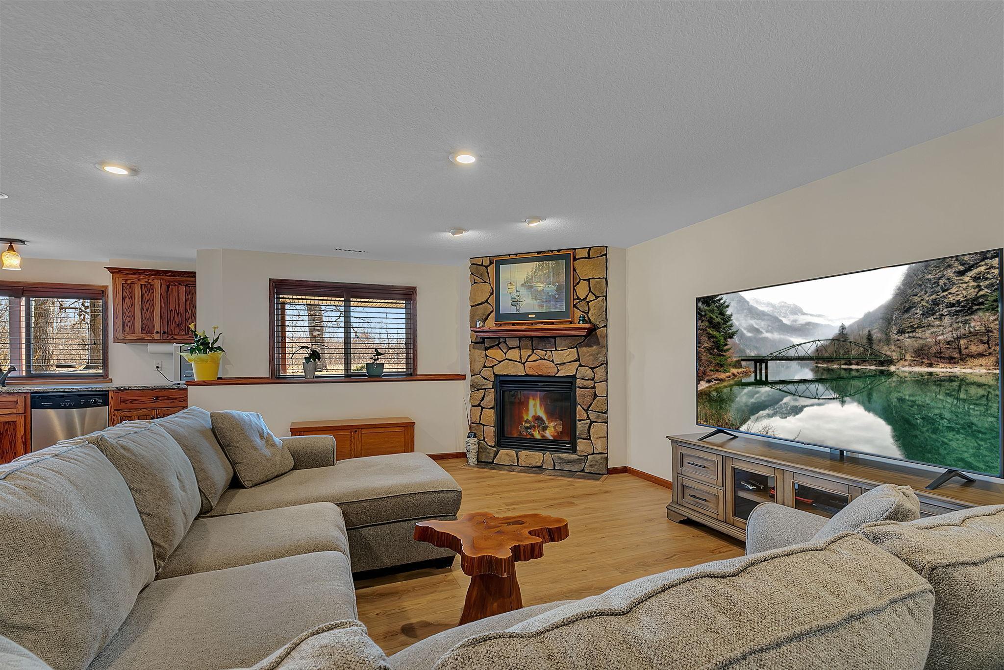 An expansive lower-level living space highlighted by a beautiful gas fireplace with stone surround—creating the perfect blend of warmth, character, and room to unwind or entertain.