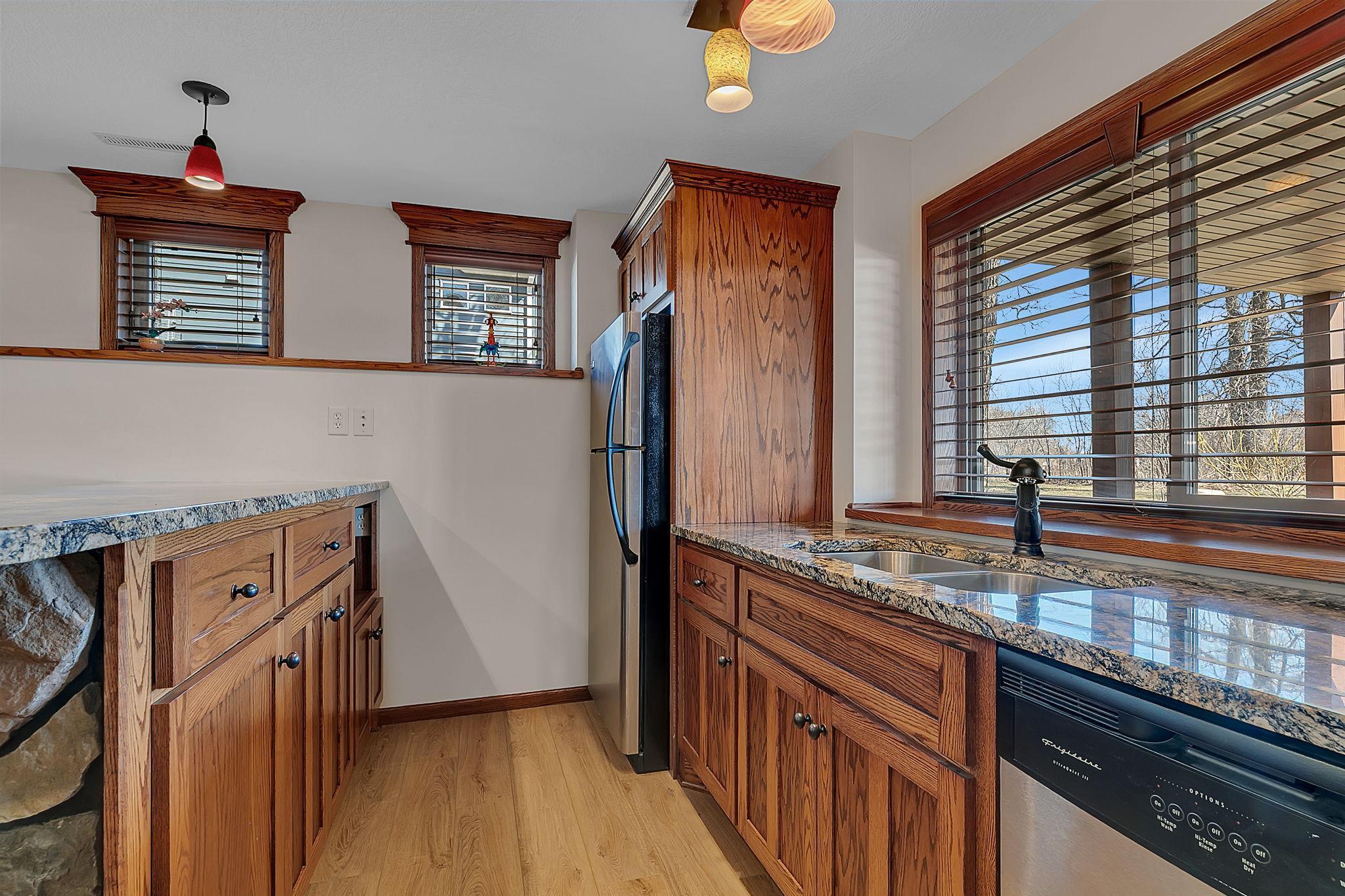 Spacious wet bar boasting plenty of cabinet storage and polished granite countertops, ideal for entertaining or everyday use.