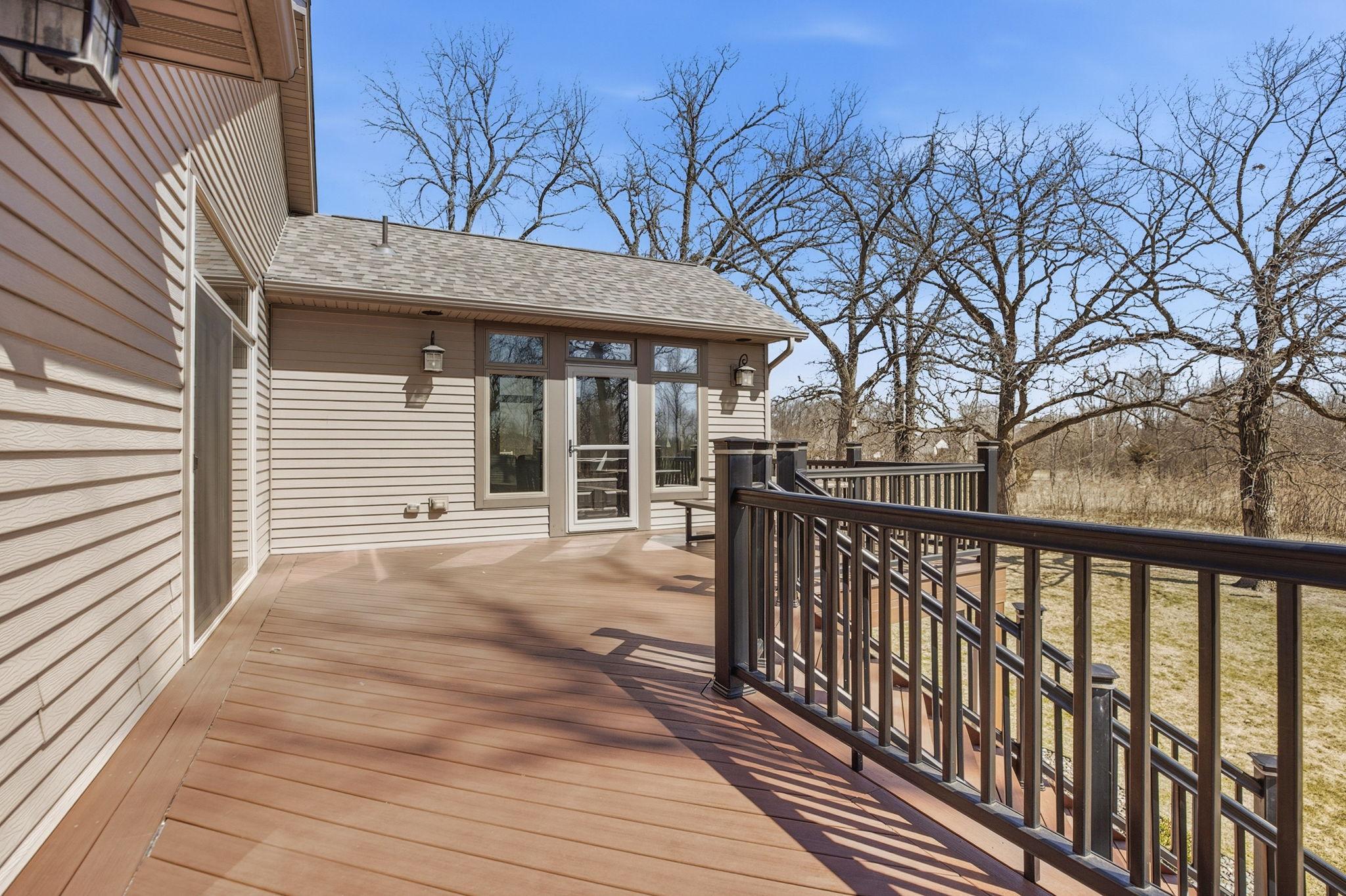 Spacious deck with easy access from both the living room and sunroom, offering seamless indoor-outdoor flow and convenient entertaining options.