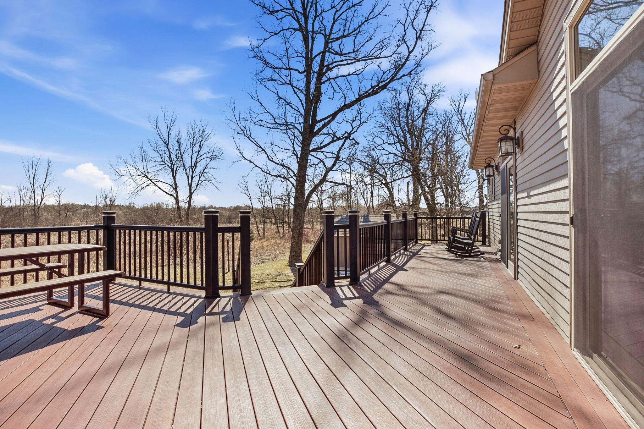 Expansive maintenance-free deck spanning the rear of the home, perfect for relaxing or entertaining while taking in picturesque backyard and natural views, enjoy all the beauty without all the upkeep.