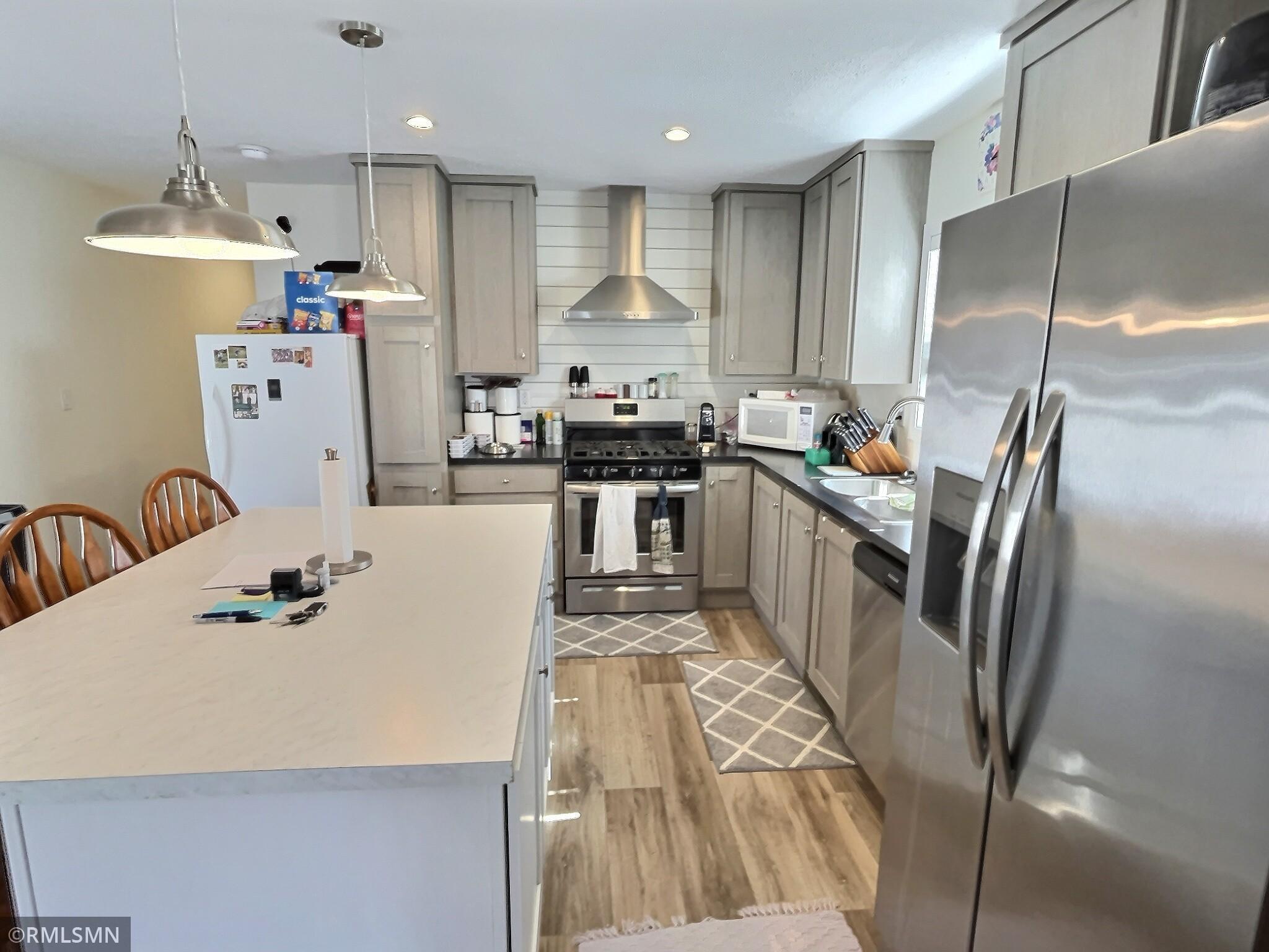 This kitchen provides modern stainless steel appliances which includes the exhaust hood above the range.