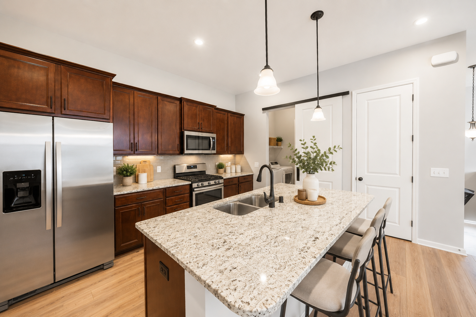 Large bright kitchen with stainless steel appliances, granite countertops and 7 ft. island, soft closing doors and drawers, pull out drawers, garbage can and recycling bin, recessed and pendent lighting, barn door, and large pantry!