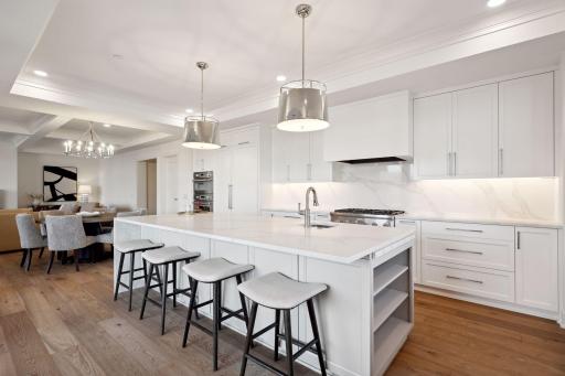 Chef's kitchen features stainless steel appliances, large oversized island with room for seating, and plenty of cabinet and counter space
