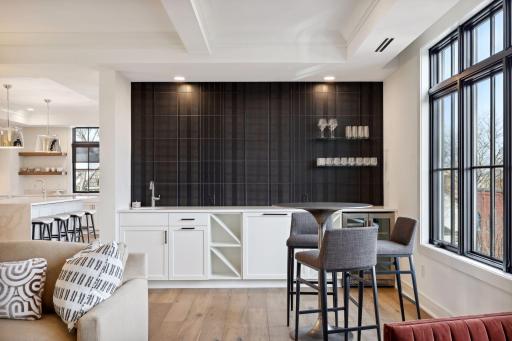 The bar area features floating shelves, sink, dual zone beverage center and a great backdrop for some impressive artwork