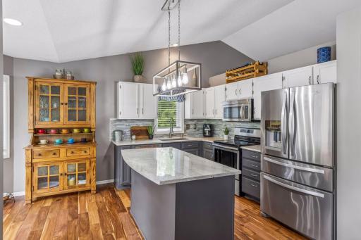 Gourmet kitchen with a large granite island, stainless steel appliances, and tons of cabinet space.