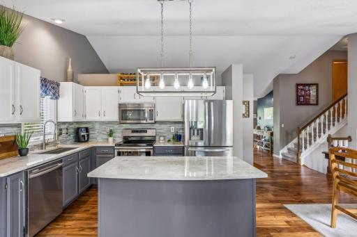Updated kitchen featuring white and gray cabinetry, granite countertops, and high-end stainless appliances.