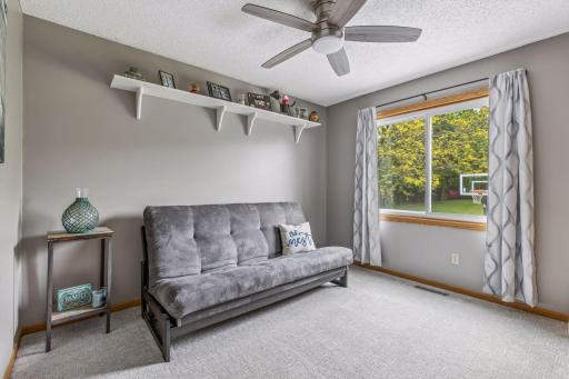 Bright secondary bedroom featuring a large closet and ceiling fan. Large window overlooking the backyard.