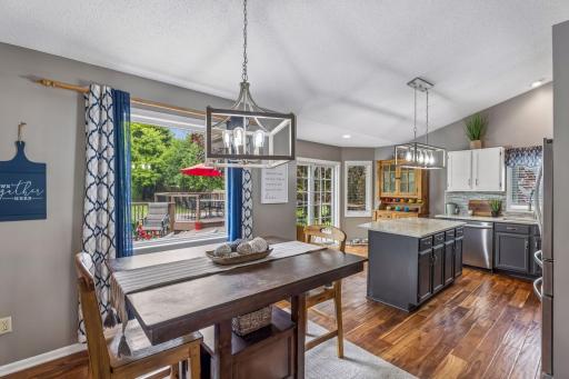 Elegant dining area with a beautiful chandelier and views of the deck and basketball court.