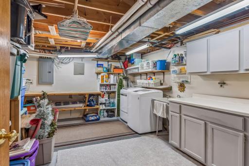 Washer, dryer, and sink in the utility room with excellent storage and workspace. Updates include HVAC/furnace and A/C (installed 2025 for approximately $20,000 last summer), water softener (2025).
