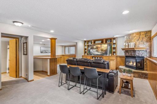 Finished lower-level family room with bar seating, ideal for relaxing or entertaining.