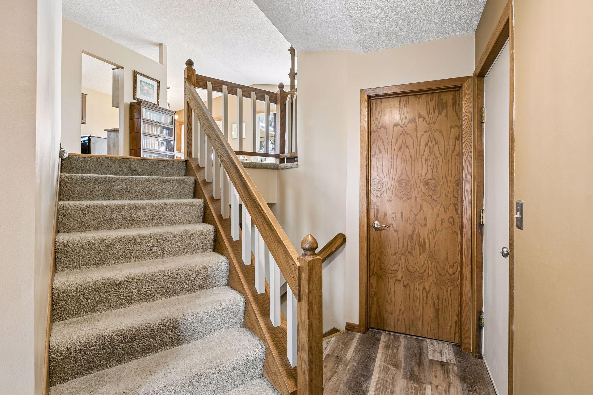 Spacious foyer entry featuring a walk-in coat closet and angled staircase, creating a welcoming first impression with both function and style.