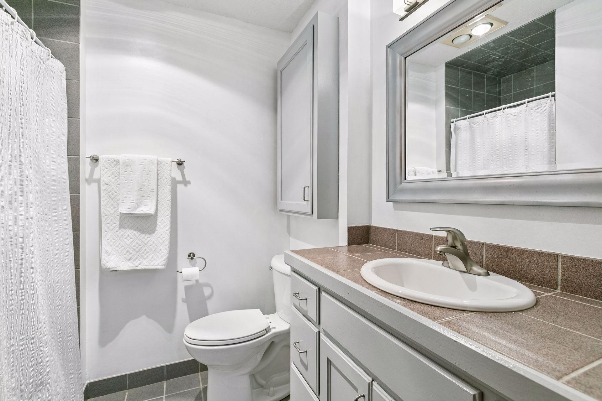 Lower level 3/4 bathroom featuring ceramic tile floors and large vanity.