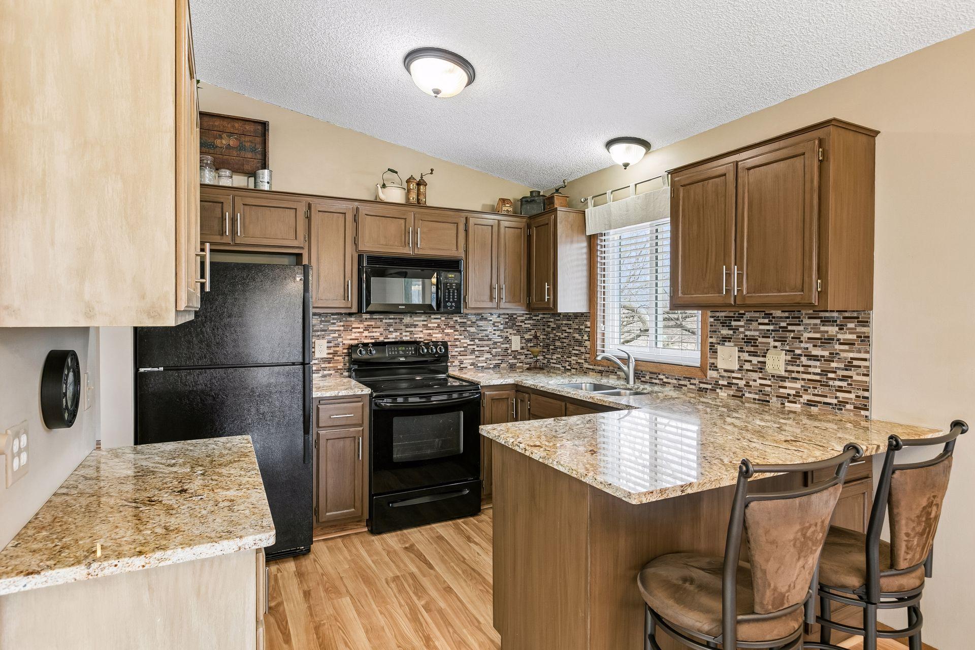 Inviting kitchen updated with granite countertops, stainless sink, generous storage, and a sunlit window, with seamless access to the informal dining area.