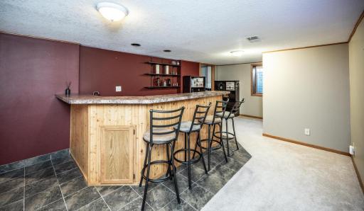 Enjoy entertaining at the lower level wet bar. Bar stools and refrigerator are included.