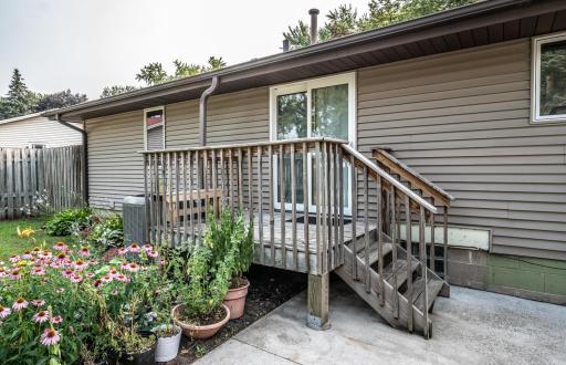 The deck leads to the large, flat backyard