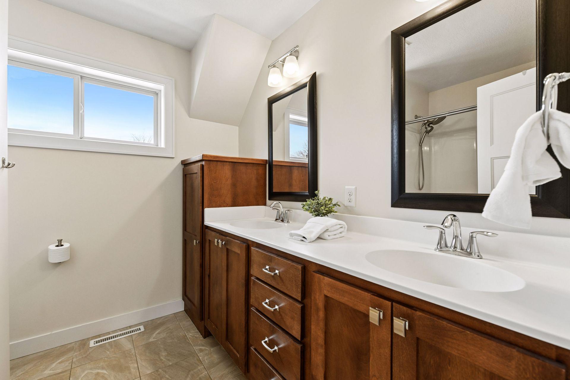 Main full bathroom on the upper level with dual sinks, tub/shower. Excellent storage