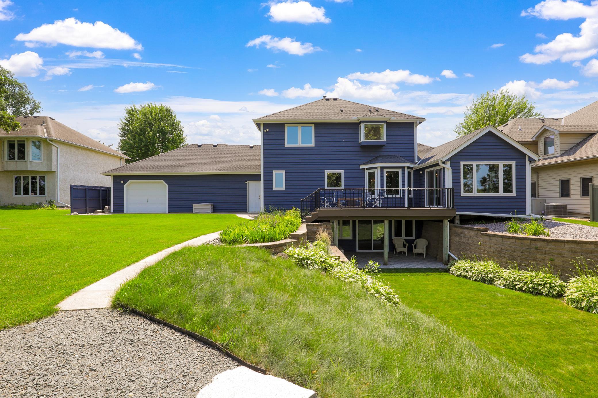Intelligently designed landscaping and retaining walls facilitate the walkout elevation of the lower level and maximize the usable yard space.