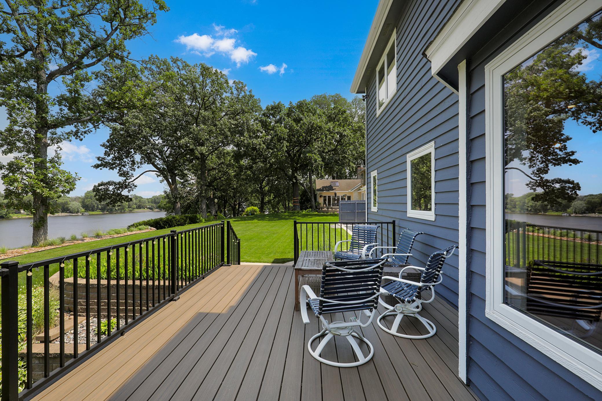 The cedar-cladded sunroom features large windows overlooking the river, vaulted ceilings, and walks out to the maintenance free deck.