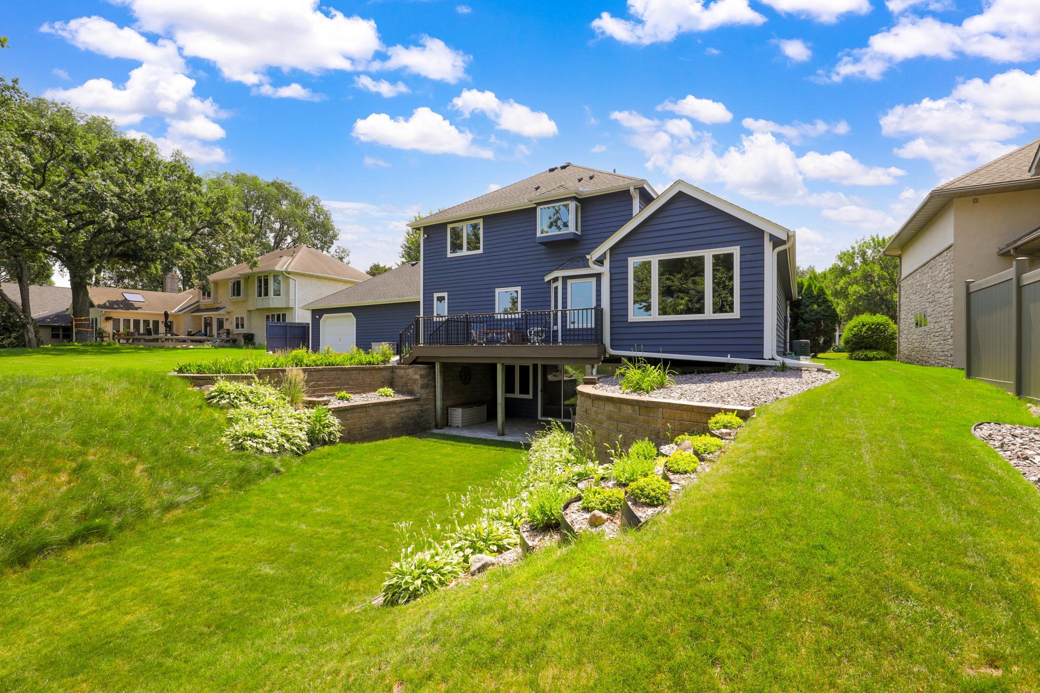 Intelligently designed landscaping and retaining walls facilitate the walkout elevation of the lower level and maximize the usable yard space.